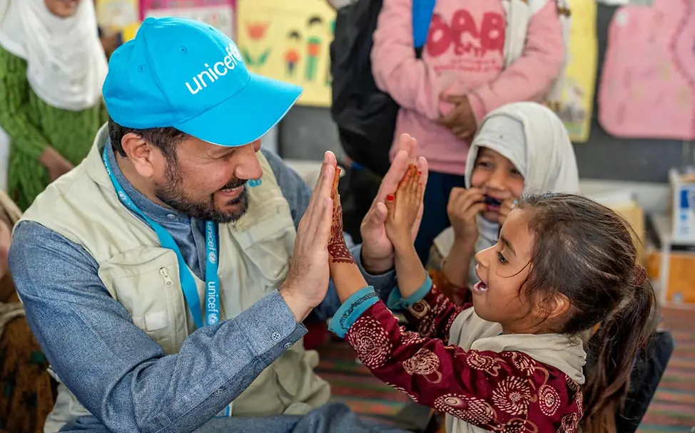 Ein Mädchen und ein UNICEF-Mitarbeiter spielen fröhlich miteinander | © UNICEF/Karimi Spenden Afghanistan: Ein Mädchen und ein UNICEF-Mitarbeiter spielen fröhlich miteinander.