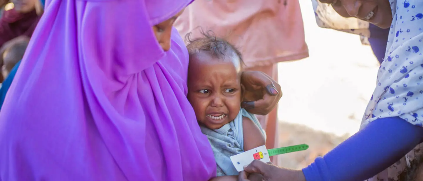Ein Kleinkind im Sudan wird von einer Gesundheitshelferin auf Mangelernährung untersucht | © UNICEF/Mohamdeen Sudan Spenden: Mangelernährte Kinder im Sudan und Nachbarländern brauchen Nahrung und Nothilfe.