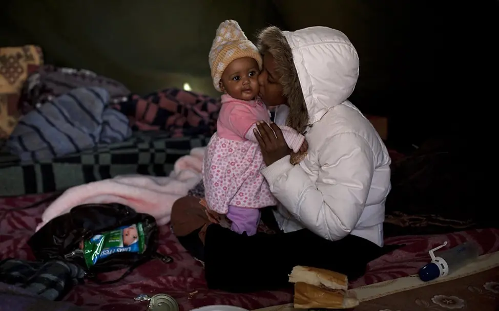 Eine somalische Frau mit ihrem Baby am Grenzposten Ras Jedir. © UNICEF/Ramoneda