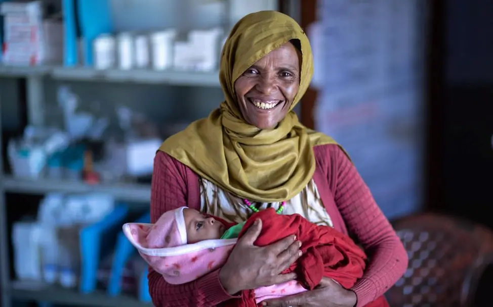 Rehima hält ihr Baby glücklich im Arm. Sie hat sich von Mangelernährung während der Schwangerschaft erholt. | © UNICEF/UN0792386/Ayene Ausgefallene Ernten führen zu einer schlechten Grundversorgung von Familien am Horn von Afrika.