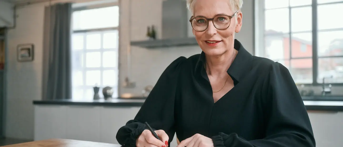 Bärbel Schäfer | © UNICEF/UN0660418/Wildelau Bärbel Schäfer sitzt an einem Tisch und schreibt in ein Buch