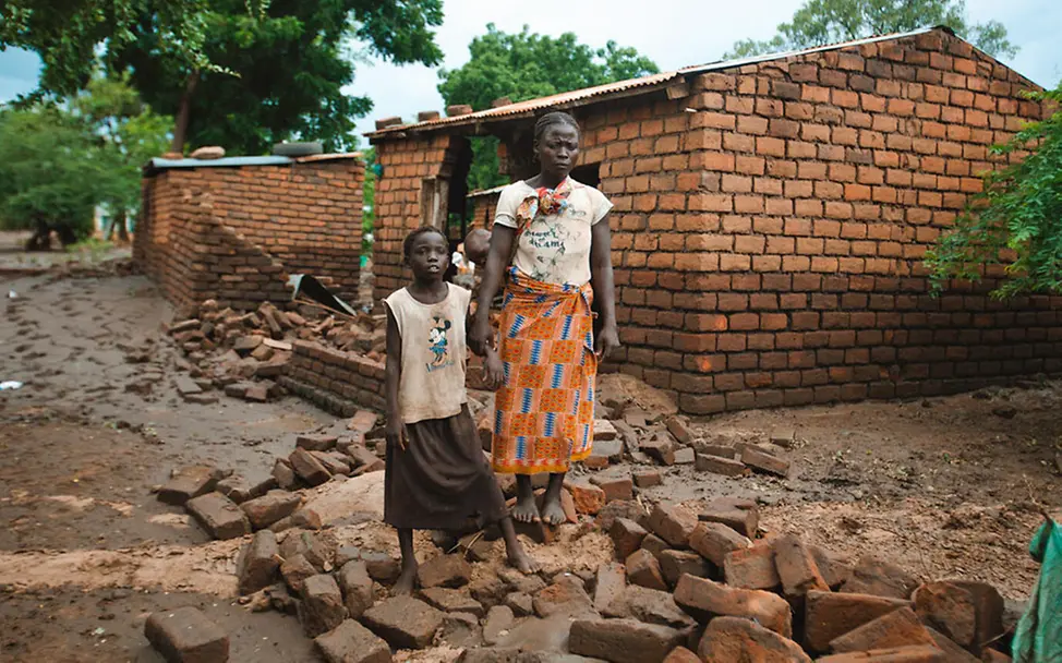 El Niño: Eine Mutter und ihre Tochter stehen in den Trümmern ihres Zuhauses | © UNICEF/PLUS CREATIONS El Niño: Erhebliche Regenfälle und Überschwemmungen brachten 2024 Millionen Familien in Gefahr.