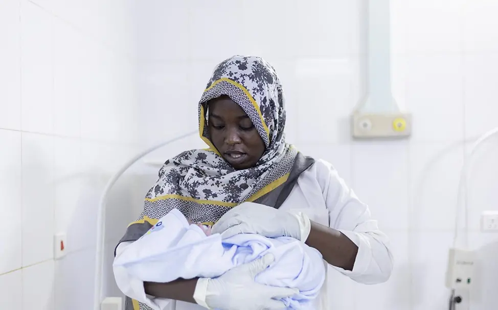 Sudan Hungersnot: Hebamme Narameg hält ein Kind im Arm