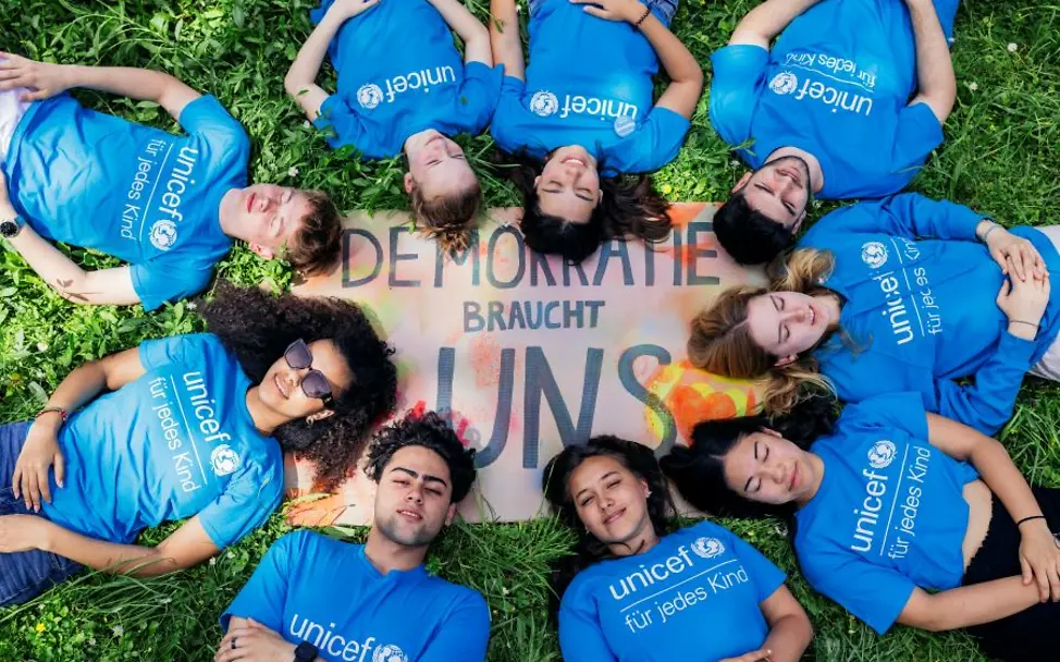 Wie stärken Kinderrechte die Demokratie?: Mehr Mitsprache, faire Chancen, Schutz vor Gewalt und Diskriminierung | © UNICEF/Stroisch Kinderrechte leben: Jugendliche liegen auf einer Wiese.