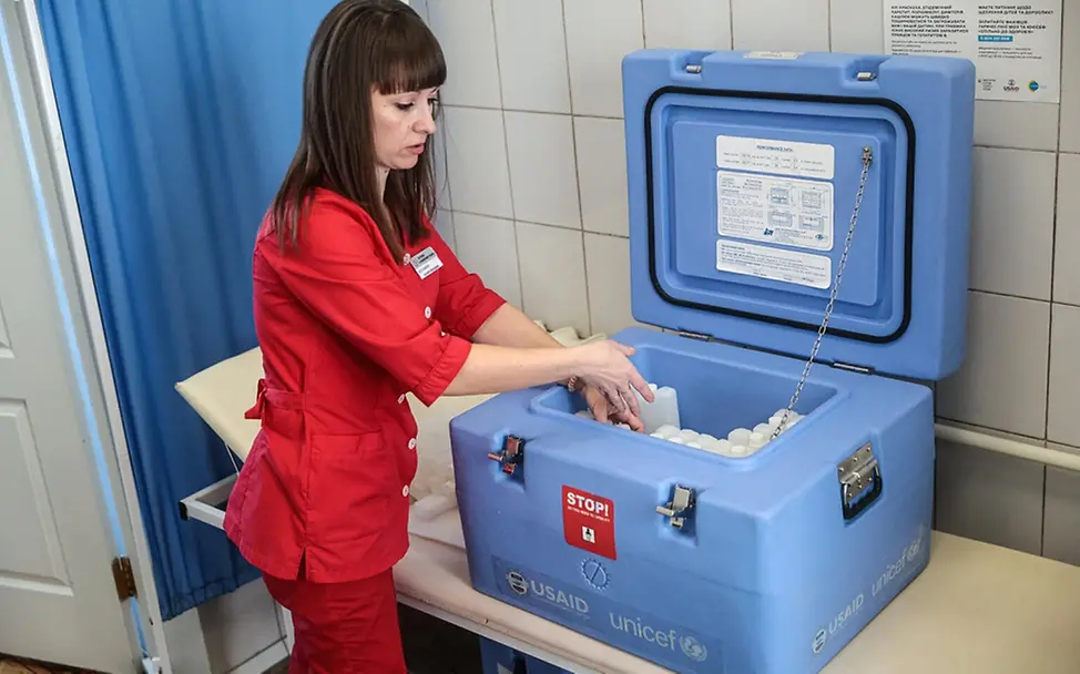 Masern gefährlich: Eine Helferin in der Ukraine legt Impfstoffe in eine Kühlbox