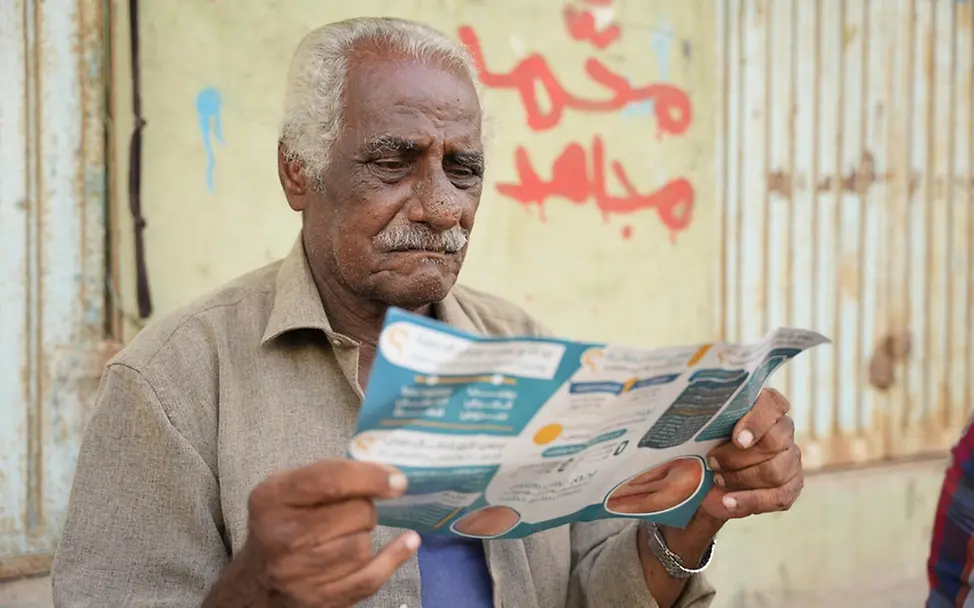 Masern gefährlich: Ein Mann im Jemen liest eine Info-Broschüre über die Masern