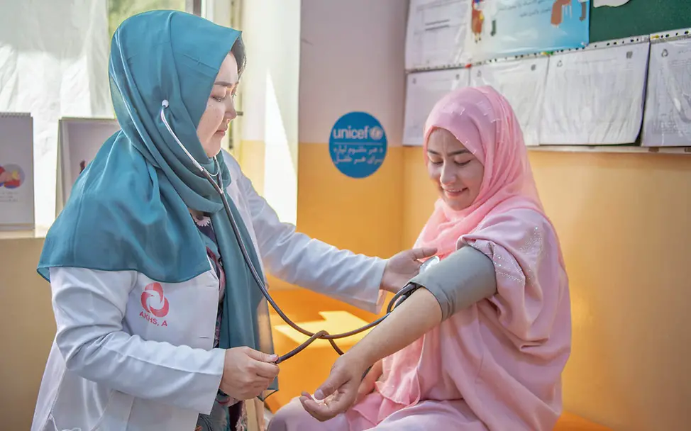 Eine UNICEF-Gesundheitshelferin untersucht eine Schwangere | © UNICEF/Musadiq Afghanistan Gesundheitshilfe: Eine Hebamme misst bei einer Schwangeren den Blutdruck.