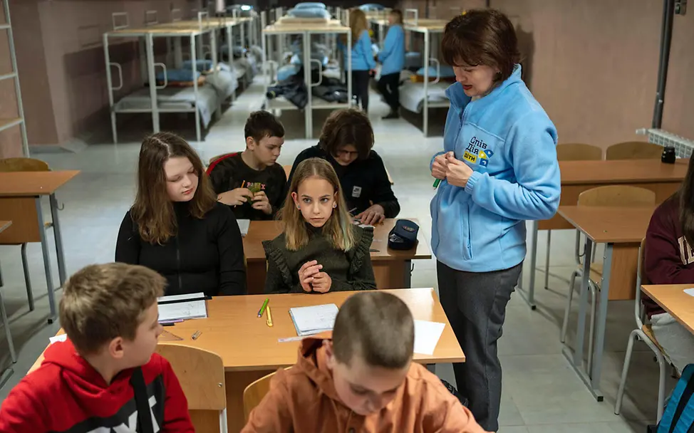 Eine | © UNICEF/Filippov Kinder im Krieg: Eine Lehrerin unterrichtet Mädchen und Jungen in einem Luftschutzbunker