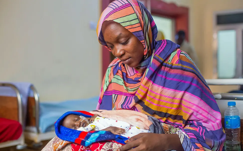 Eine Mutter im Sudan hält ihr mangelernährtes Baby auf dem Schoß | © UNICEF/Isamaldeen Kinder im Krieg: UNICEF kümmert sich um die Gesundheit von Kindern im Krieg