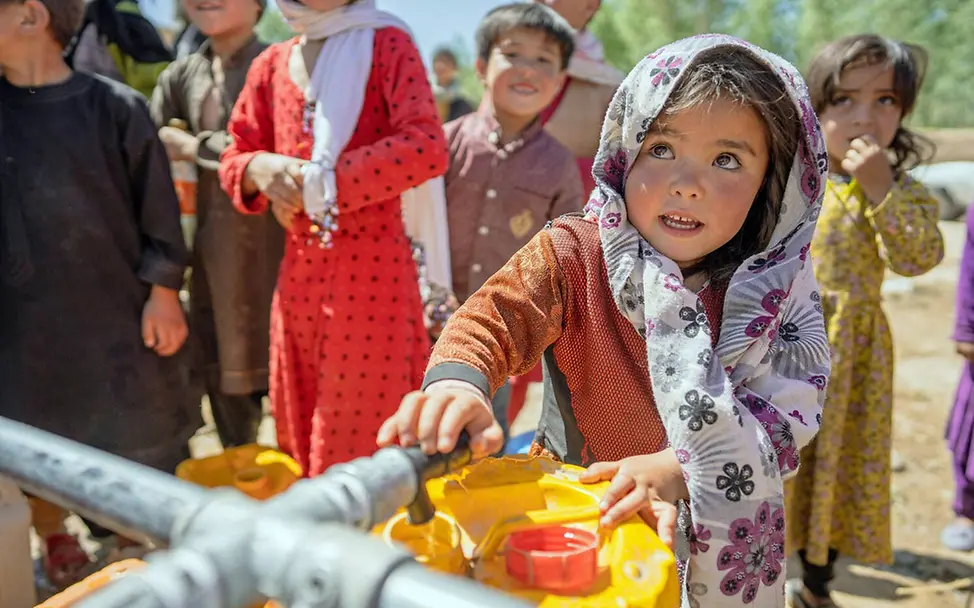 Für Wasser & neue Brunnen spenden: Ein Mädchen in Afghanistan befüllt einen Wasserkanister mit frischem Trinkwasser