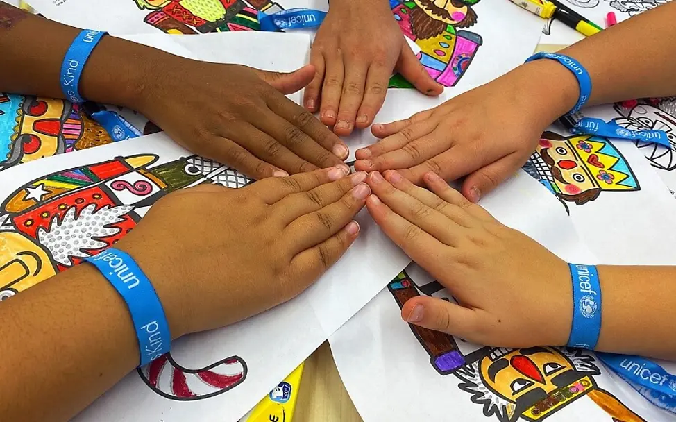 Schule aktiv für UNICEF. | © UNICEF/Grass Kinderrechteschulen: Kinder von der Waldhausschule halten ihre Hände in die Mitte.