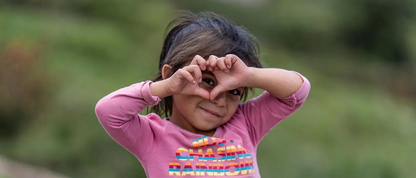 Guatemala: Ein Mädchen lächelt und bildet mit ihren Händen ein Herz. | © UNICEF/Flores Guatemala: Ein Mädchen lächelt und bildet mit ihren Händen ein Herz.