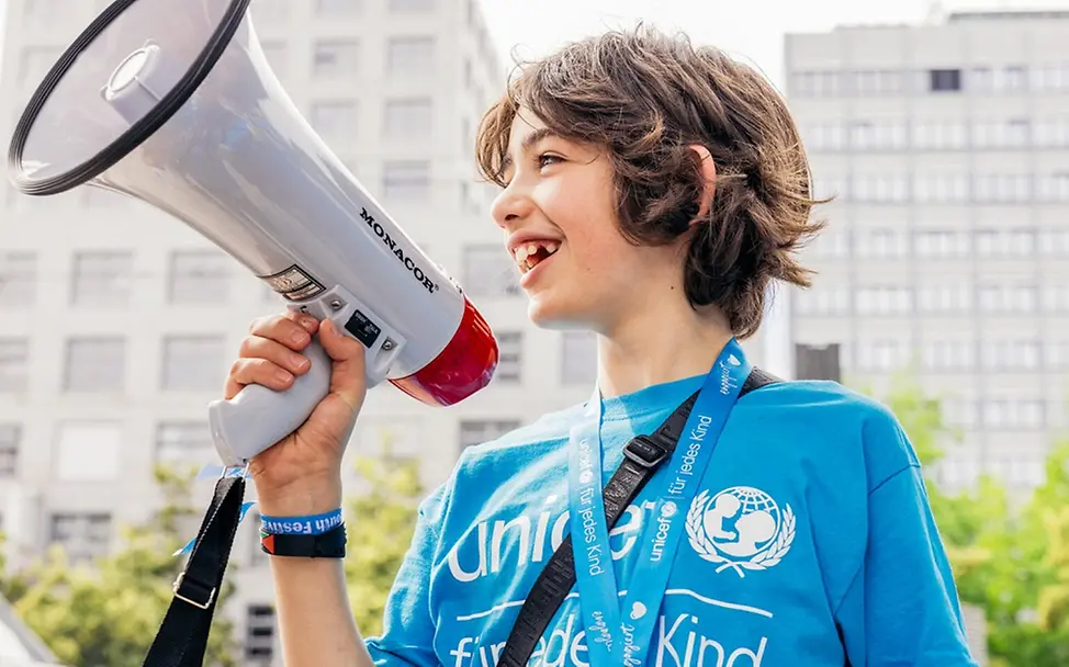 Bundestagswahl für Kinder erklärt: Ein Kind in UNICEF-Shirt mit Megafon | © UNICEF/Stroisch Bundestagswahl für Kinder erklärt: Ein Kind in UNICEF-Shirt mit Megafon