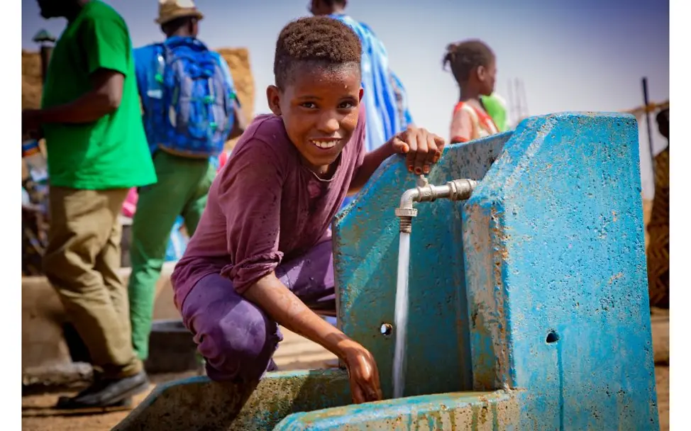 Mauretanien: Ein Junge sitzt an einem Brunnen.