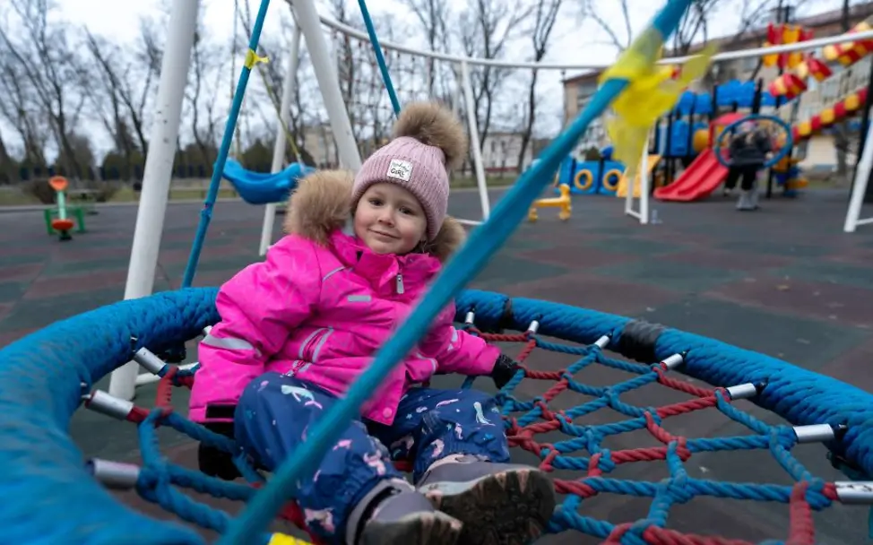 Ukraine: Ein Mädchen sitzt in einer Schaukel. 