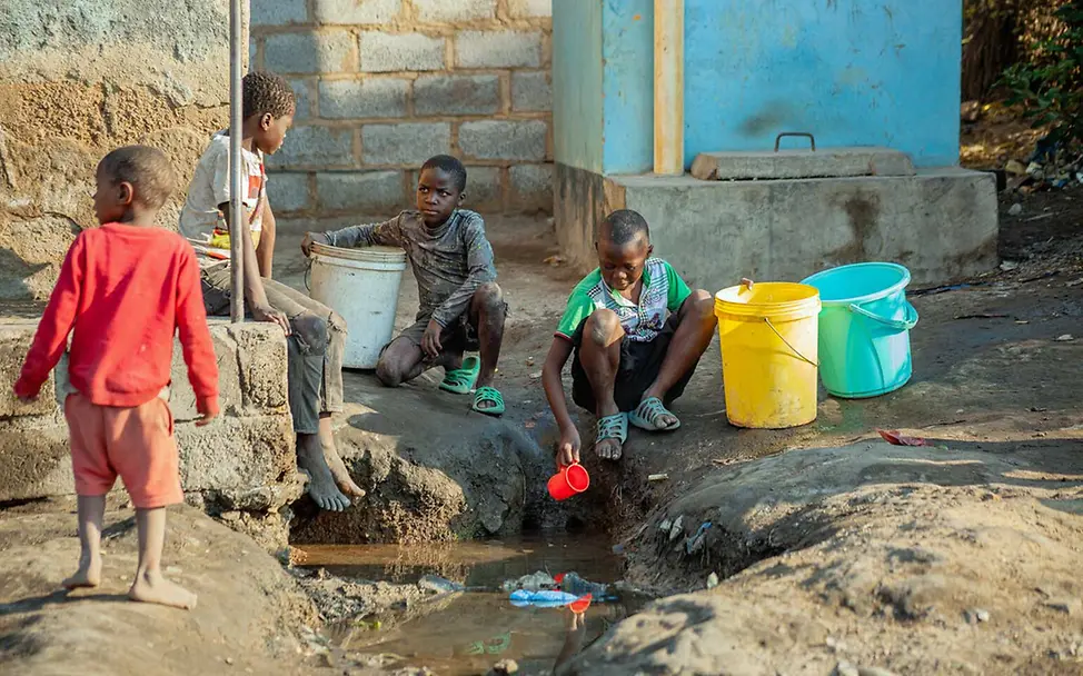 Sambia Wasser: Kinder schöpfen Wasser aus einem Wassergraben in Lusaka, der Hauptstadt Sambias 