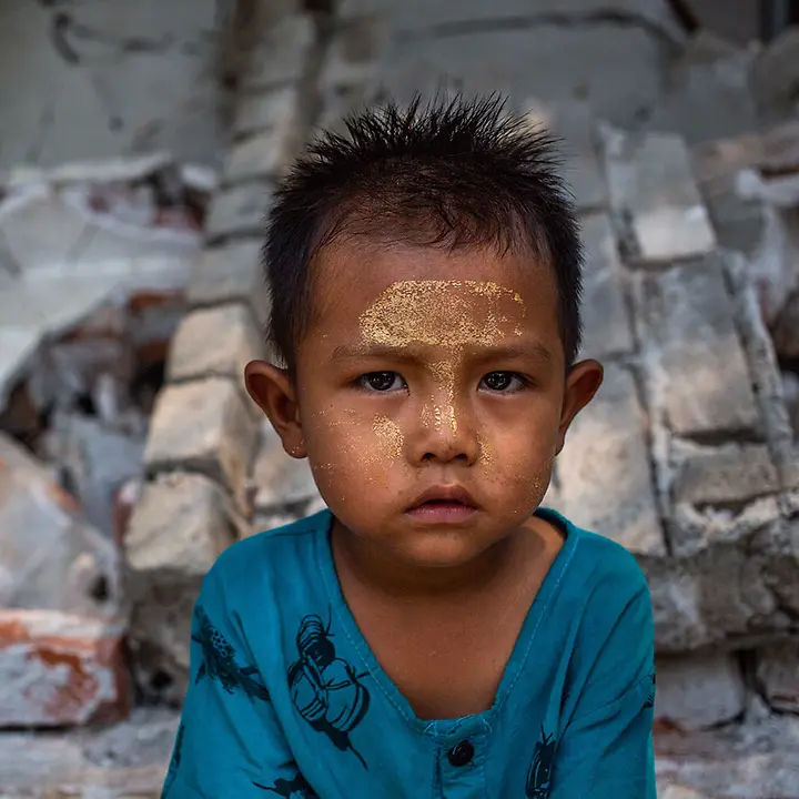 Erdbeben Myanmar spenden: Ein Junge sitzt nach dem schweren Erdbeben vor den Trümmern von Gebäuden 