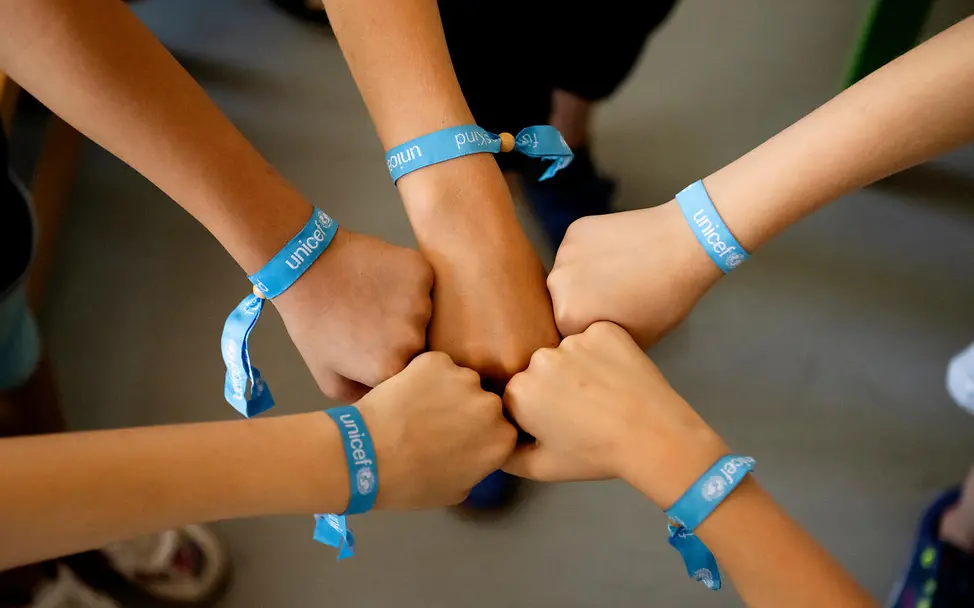 | © UNICEF/UNI825006/Etges Handgelenke mit UNICEF-Armbändern