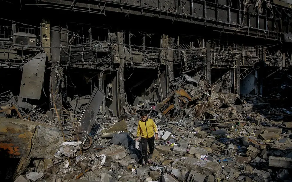 Ali (11) zwischen zerstörten Gebäuden.