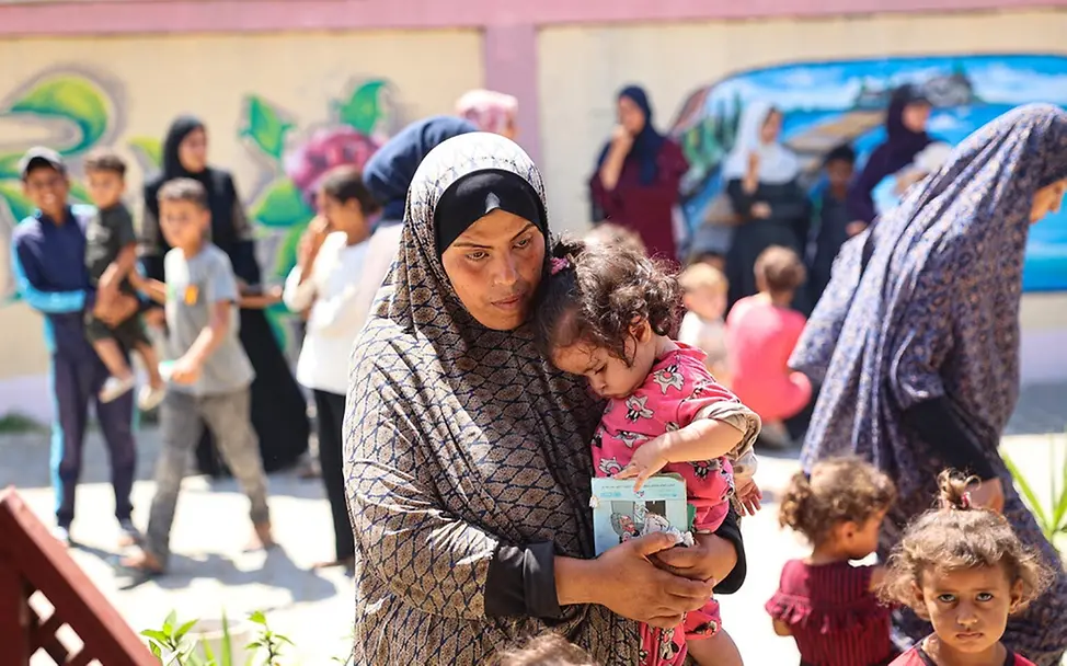 Mutter und Tochter warten auf eine Untersuchung in einer von UNICEF unterstützten Klinik