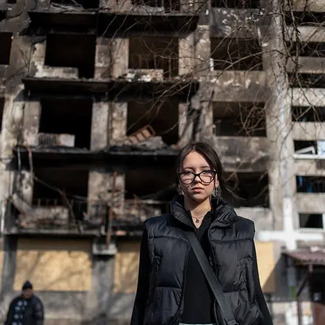 Ukraine Teenager: Die 14-jährige Alina steht vor einem beschädigtem Wohnhaus