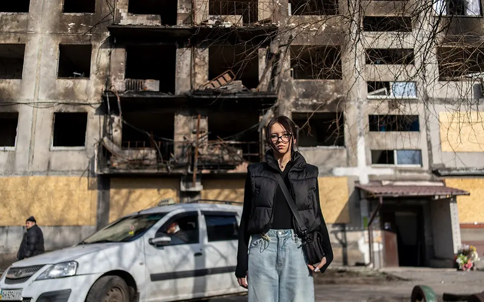 Ukraine Teeneger: Die 14-jährige Angelina steht vor einem beschädtigten Wohnhaus 