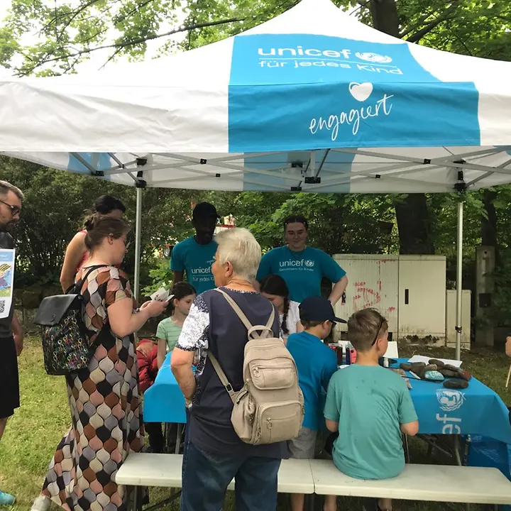 Der Stand der UNICEF-AG Dresden zum Kindertag mit bastelnden Kindern und Besuchern.