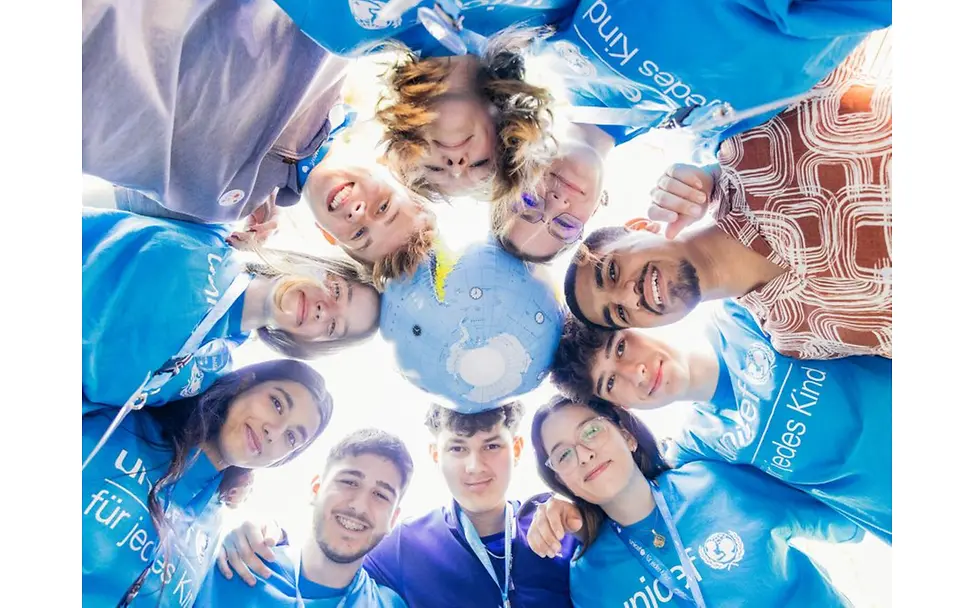 Kreis aus jungen Menschen beim Youth Festival, in der Mitte ein Globus.