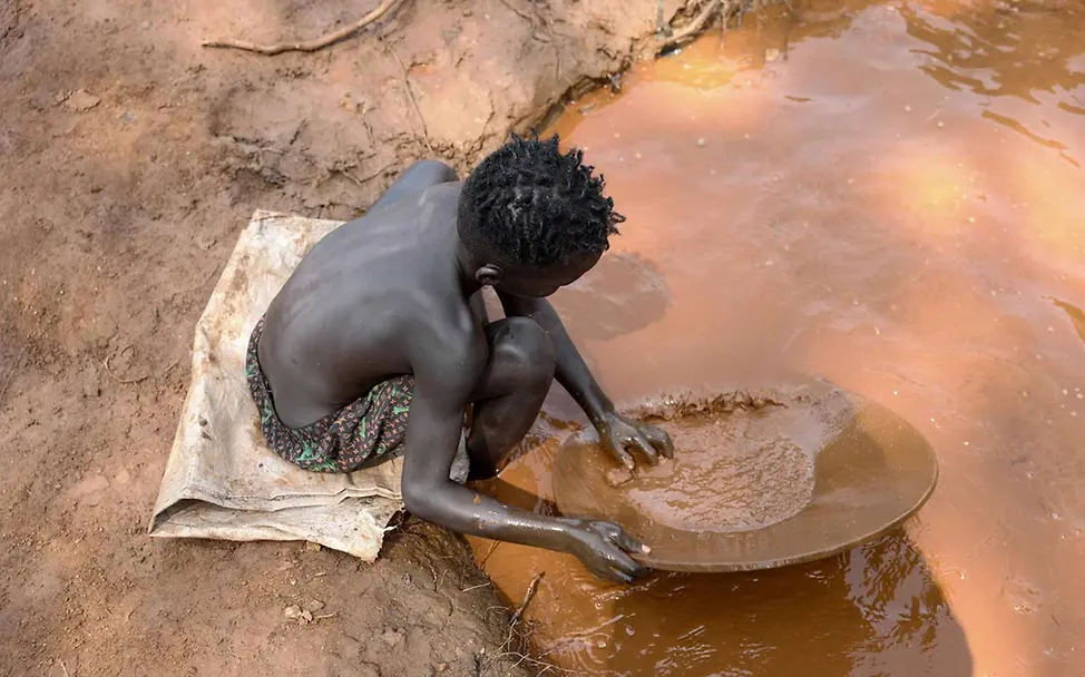Ein Junge in Äthiopien schürft an einer Wasserstelle nach Gold | © UNICEF/Bizuwerk Was kann man gegen Kinderarbeit tun: Ein Junge in Äthiopien schürft an einer Wasserstelle nach Gold.