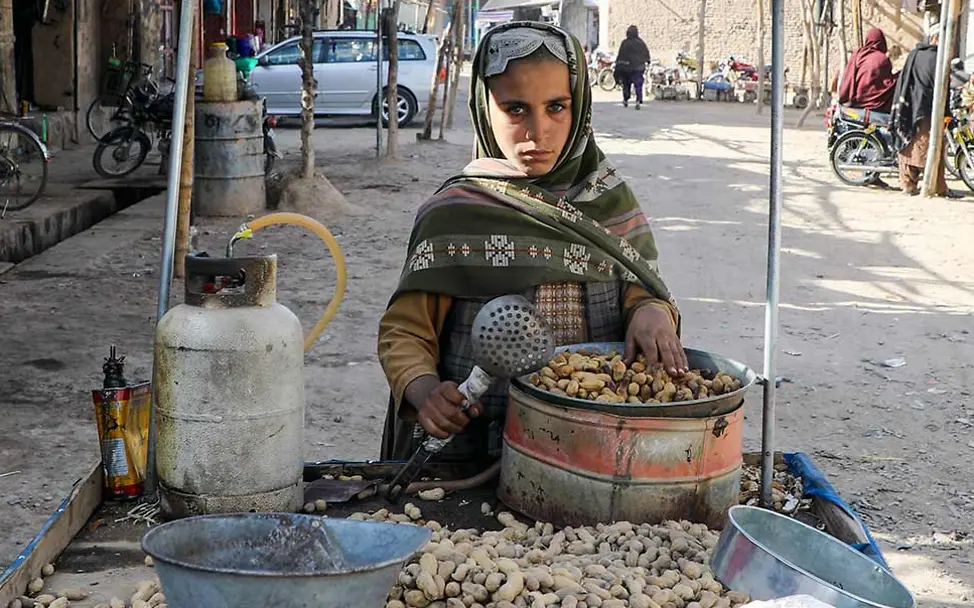 Ein Junge in Afghanistan verkauft an einem kleinen Stand geröstete Erdnüsse. | © UNICEF/Fazel Was kann man gegen Kinderarbeit tun: Ein Junge in Asien verkauft geröstete Erdnüsse.