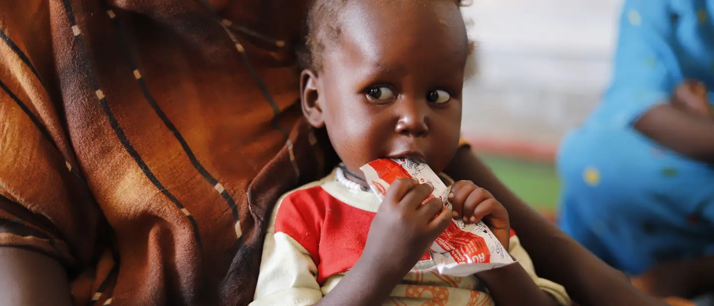 Ein unterernährtes Kind isst therapeutische Nahrung in einer von UNICEF unterstützten Klinik Tawila, Nord-Darfur. | © UNICEF/UNI789976/Jamal Ein unterernährtes Kind isst therapeutische Nahrung in einer von UNICEF unterstützten Klinik Tawila, Nord-Darfur.