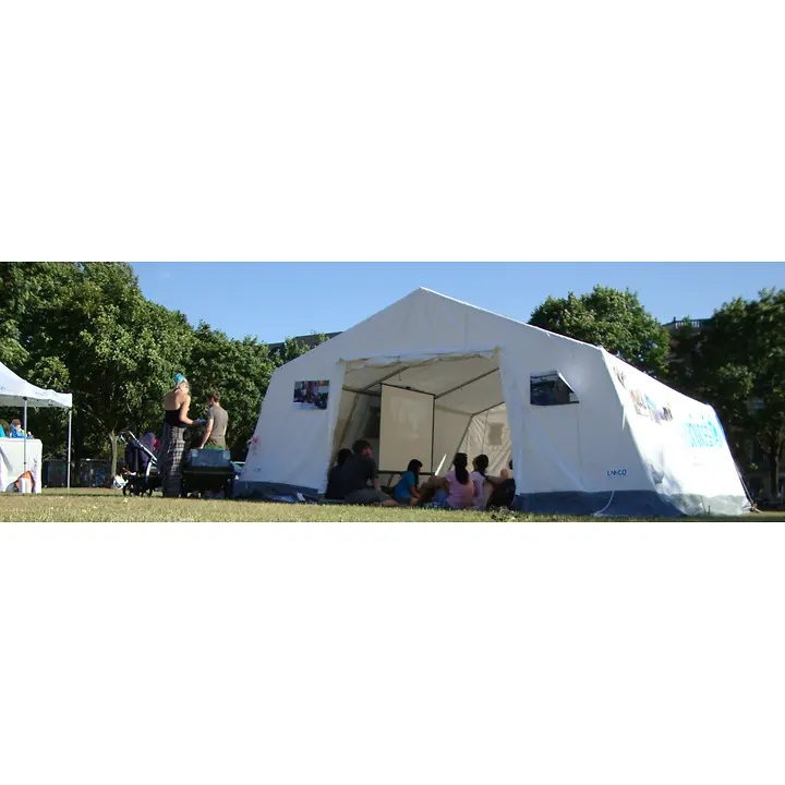 In einem großen weißen Zelt mit UNICEF-Banner sitzen Interessierte und nehmen an der Aktion zum Weltflüchtlingstag teil