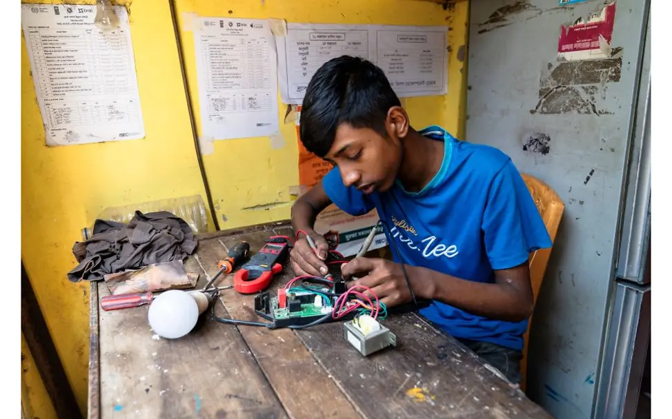 Nazmul Helali beim Arbeiten mit einem Lötgerät.