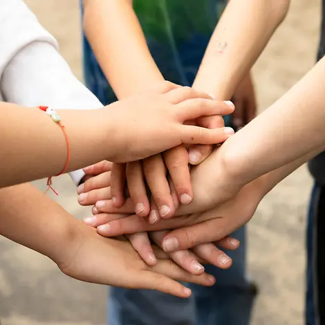 Bild von übereinandergelegten Kinderhänden.