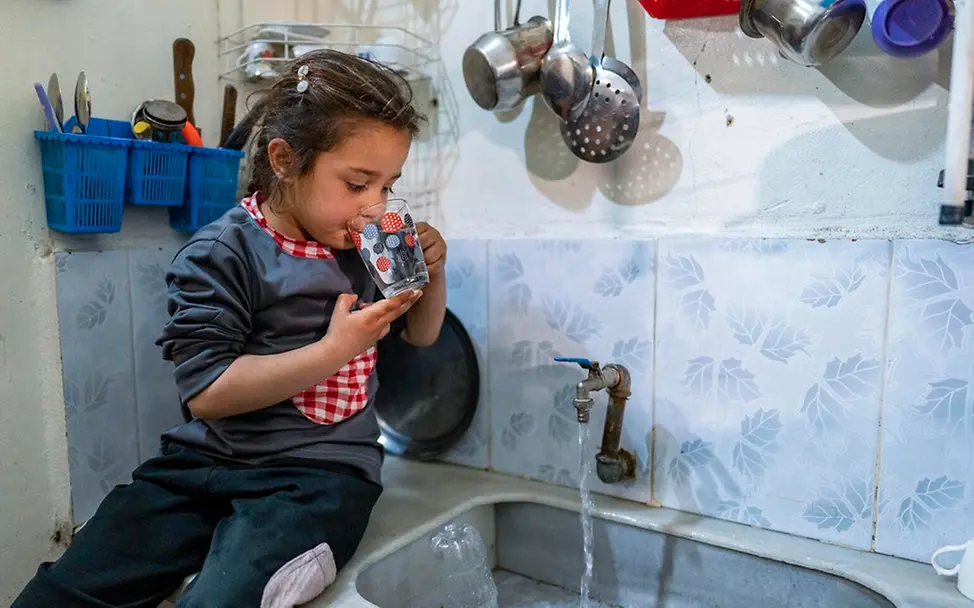 Sahar (6) trinkt in der Küche ein Glas Wasser. | © UNICEF/Chnkdji Sahar (6) trinkt in der Küche ein Glas Wasser.