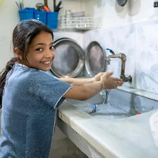 Fatima, 11 wäscht sich glücklich die Hände. | © UNICEF/Chnkdji Fatima, 11 wäscht sich glücklich die Hände.