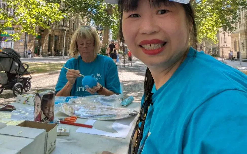 Stand beim Schaubudensommer auf der Hauptstraße in Dresden Zwei Frauen aus der UNICEF-AG Dresden sitzen am Stand mit Malsachen und Infos zu Kinderrechten