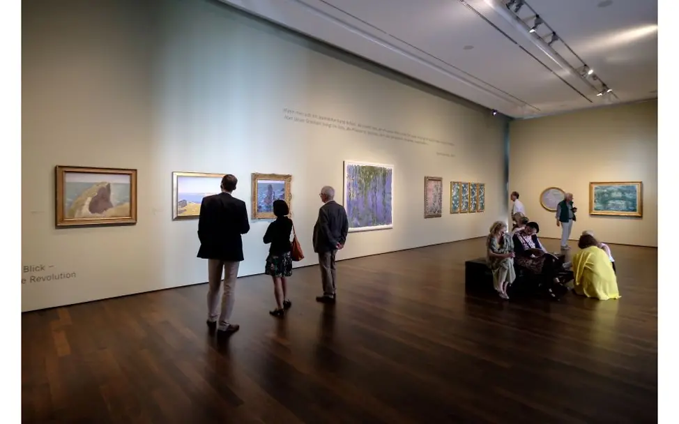 Sammlung Rau: Besucher*innen schauen sich Bilder im Arp-Museum an