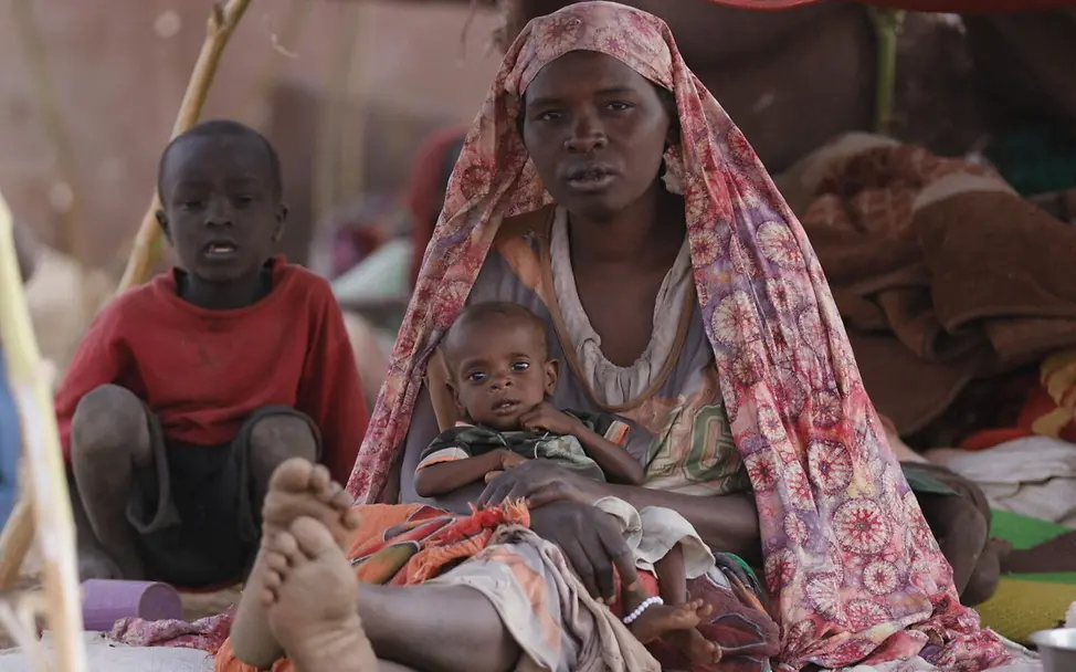 Hawa hält ihren kleinen Sohn Waleed in einer Notunterkunft in Tawila