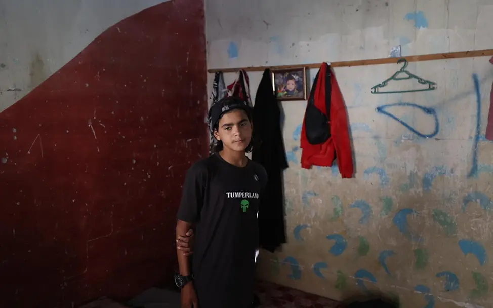 Ibrahim (14) hat seinen geliebten Vater verloren. | © UNICEF/El Baba Der 14-jährige Ibrahim hat seine Arme hinter dem Rücken verschränkt und schaut zu Boden.