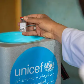 Impfungen müssen stets kühl gelagert und transportiert werden. | © UNICEF/UNI777841/Azizi Eine Impfung wird in einer Kühlbox gelagert.