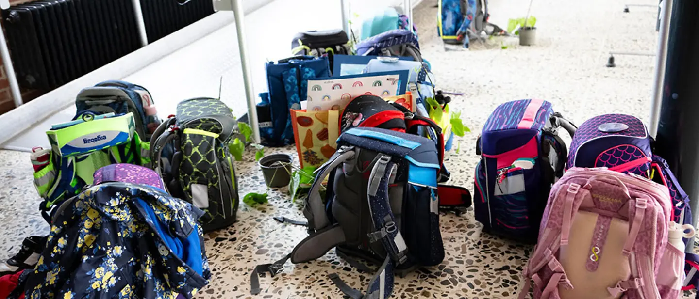 Verschiedene Schulranzen im Schulflur.