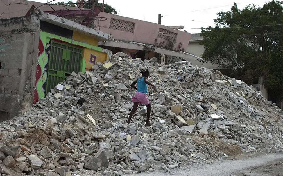 Ein Mädchen läuft über die Trümmer zerstörter Gebäude. | © UNICEF/Ramoneda Wie entstehen Erdbeben: Kinder Haiti