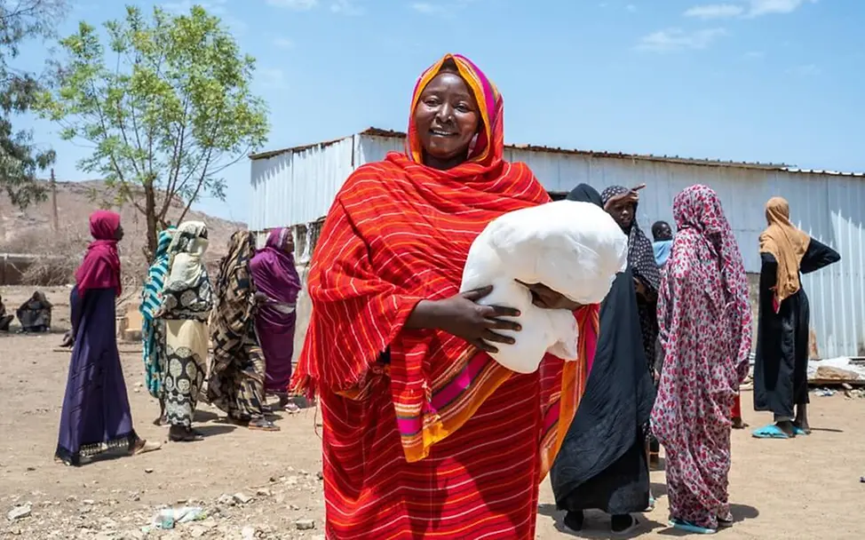 Sudan: Eine Mutter bekommt von UNICEF ein Moskitonetz zum Schutz vor Malaria | © UNICEF/Rajab Sudan: Eine Mutter bekommt von UNICEF ein Moskitonetz zum Schutz vor Malaria
