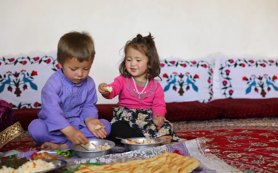Afghanistan: Zwei Kinder essen gemeinsam zu Mittag. 