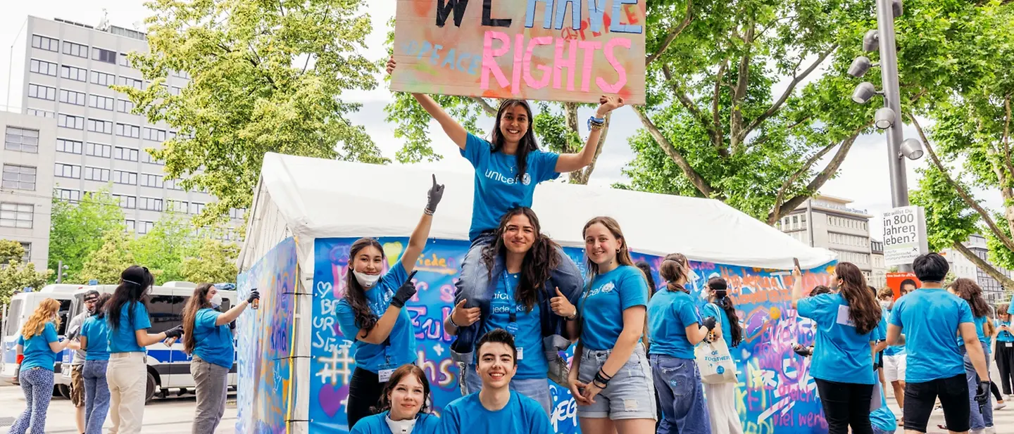 eine Gruppe Jugendliche auf dem UNICEF Youth Festival in Mannheim mit einem Schild, auf dem "We have rights" steht.