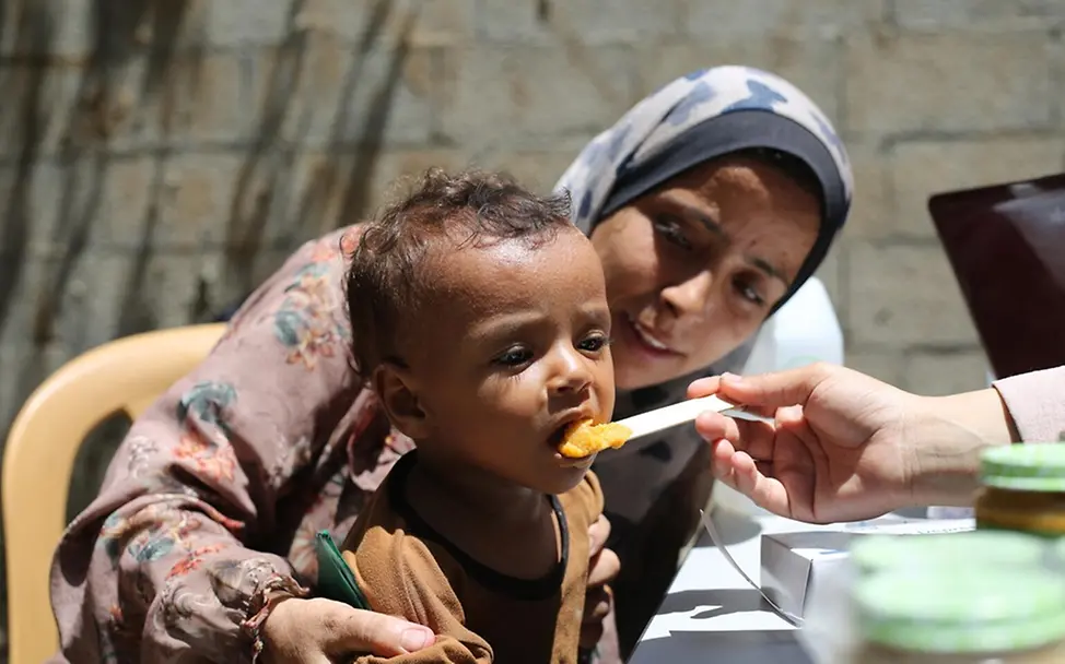 Kinder Gaza: Junge wird mit therapeutischer Spezialnahrung gefüttert.
