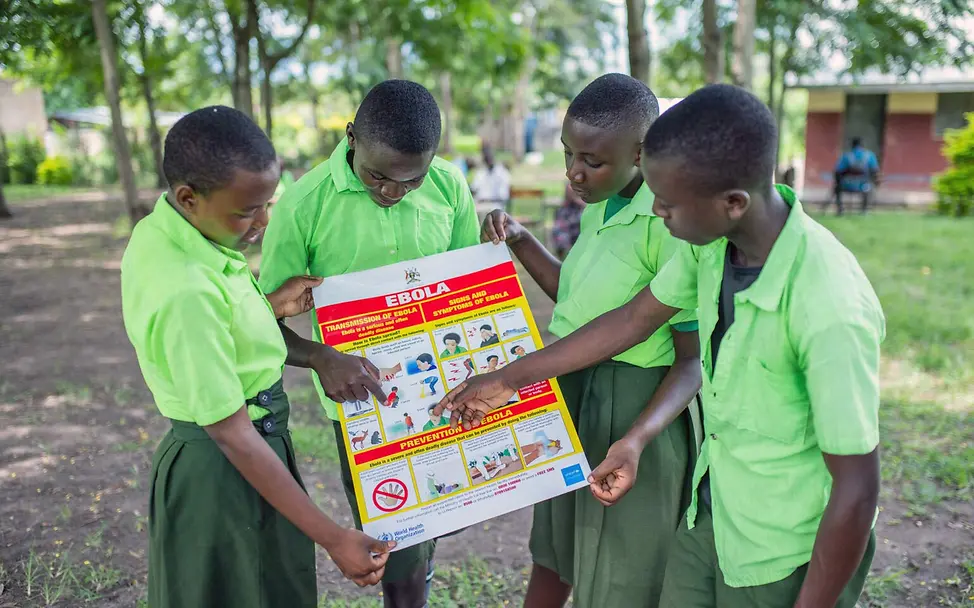 Schülerinnen und Schüler in Uganda sehen sich ein Infoplakat zu Ebola an. | © UNICEF/Bamulanzeki Ebolaaufklärung: Schülerinnen und Schüler in Uganda sehen sich gemeinsam ein Infoplakat zu Ebola an.