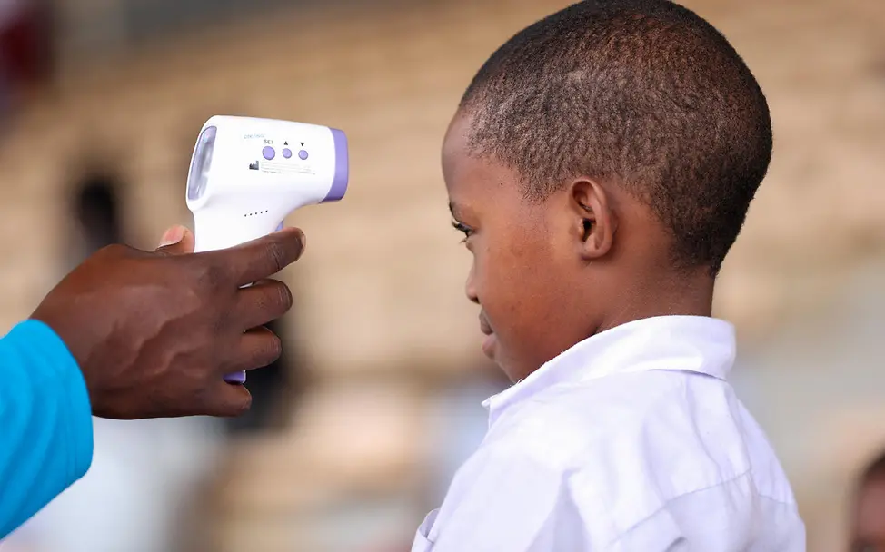 Bei einem Schüler in Uganda wird mit einem Fieberthermometer die Temperatur gemessen. | © UNICEF/Balikuddembe Ebola Früherkennung: Bei einem Schüler in Uganda wird mit einem Fieberthermometer die Temperatur gemessen.