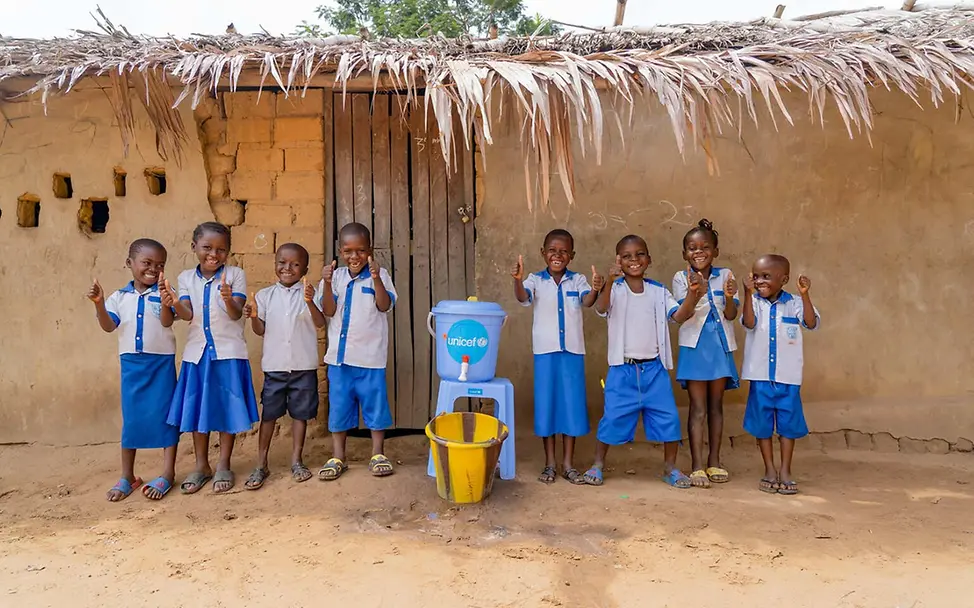 Kinder stehen vor ihrer Grundschule neben einer von UNICEF installierten Handwaschstation. | © UNICEF/Mulala Ebola Kongo: Kinder stehen vor ihrer Grundschule neben einer von UNICEF installierten Handwaschstation.